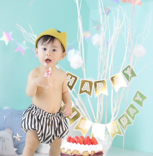 男の赤ちゃんがケーキを食べている写真